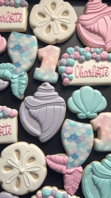 Pastel mermaid cookies for a first birthday: tails, shells, a starfish and a lilac number one.